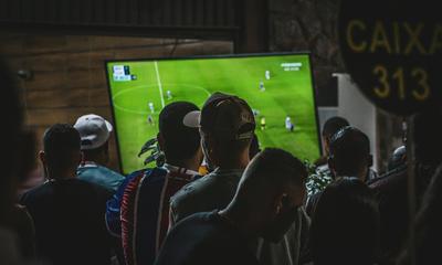 A group of people watching a soccer game on TV