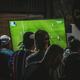 A group of people watching a soccer game on TV